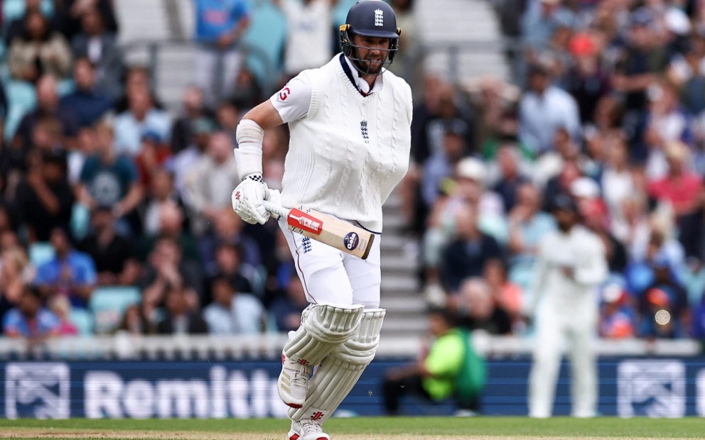 Chris Woakes strides to the crease, arm strapped in a sling.